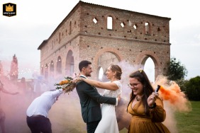 At Domaine du Beyssac in Cintegabelle, witnesses form a vibrant circle around the newlyweds, filling the air with colorful smoke from grenades, while everyone cheers and celebrates under the bright haute-Garonne sky.
